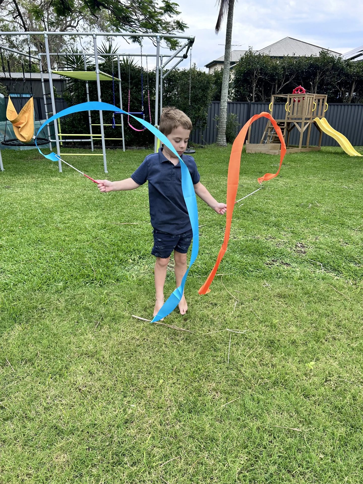 Boy playing with ribbons in the backyard