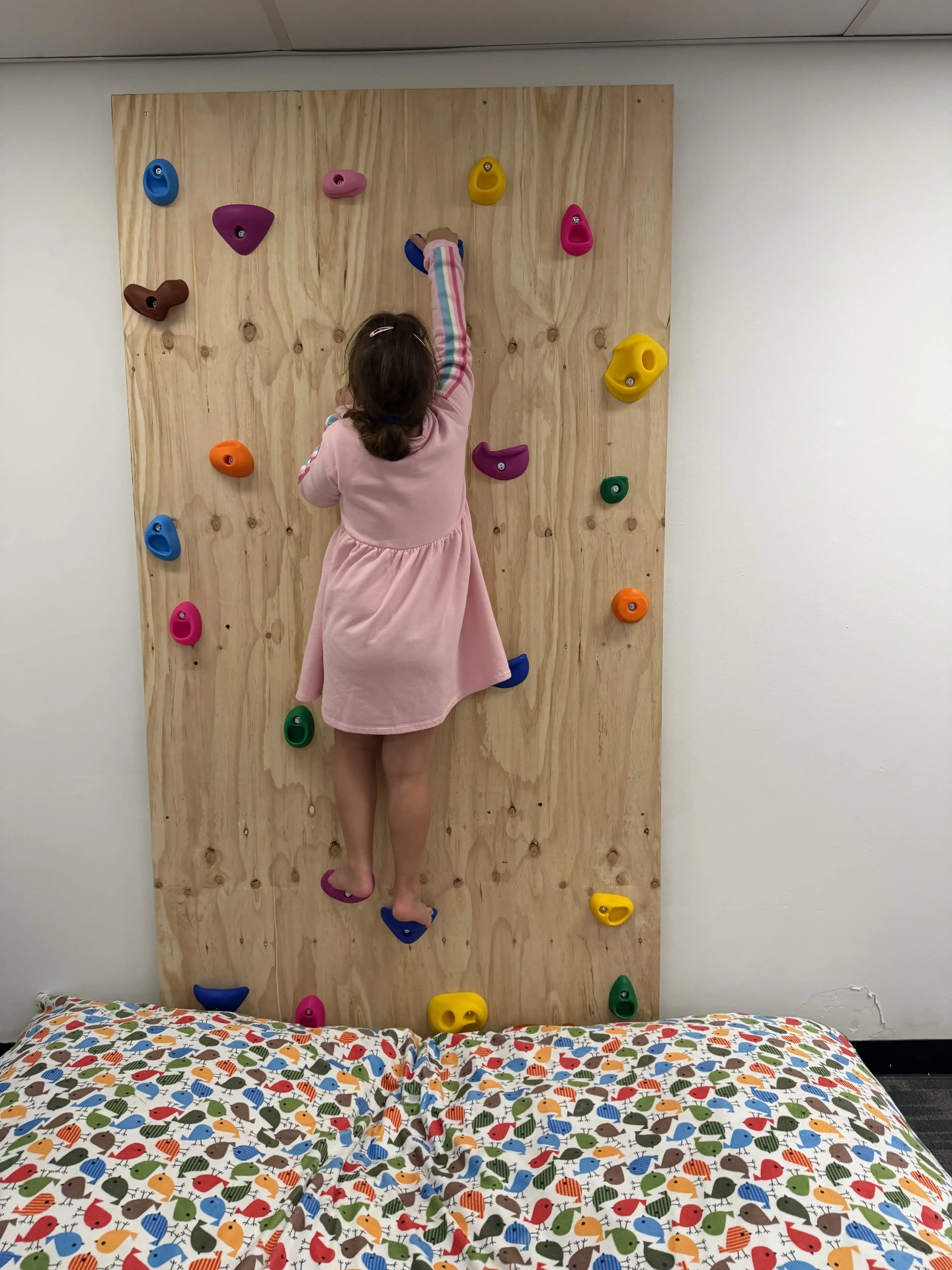 Girl on a colourful climbing wall